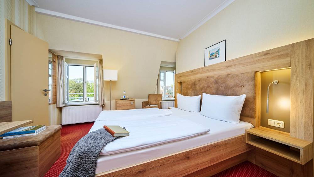 Helles Doppelzimmer mit gemütlicher Sitzecke im Strandhotel Garni Kormoran an der Ostsee.