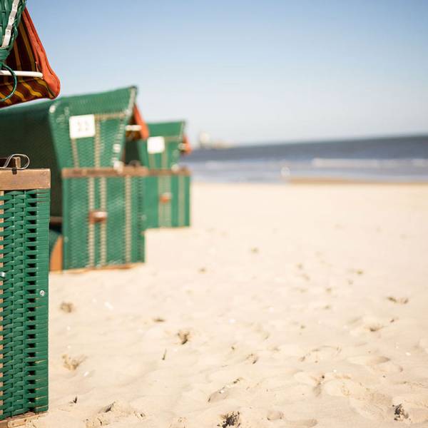 Grüne Strandkörbe auf hellem Sandstrand mit Blick auf die Ostsee für Strandurlaub im Hotel von Schöner Inseln auf Usedom.