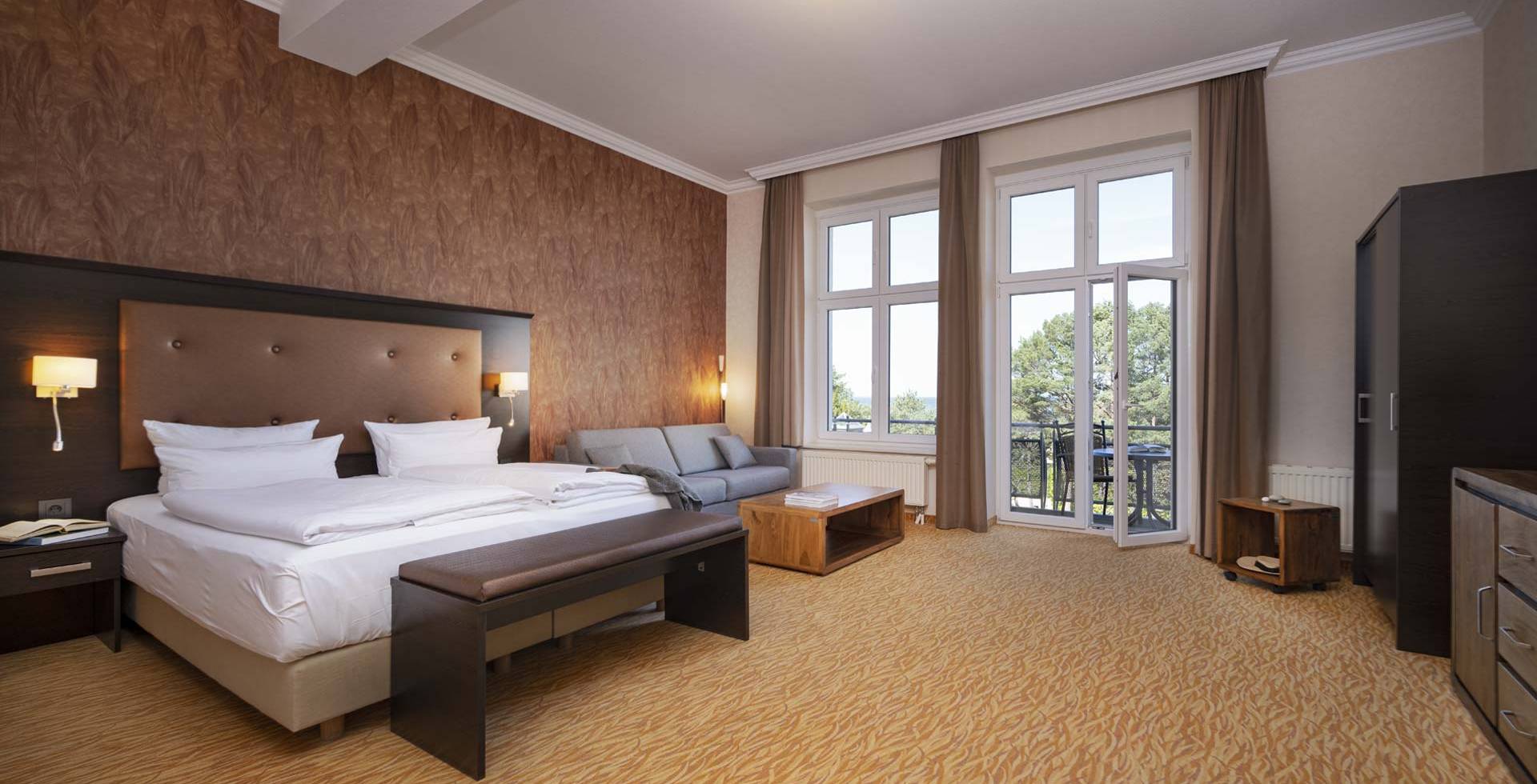 Großes Doppelzimmer im Strandhotel Preußenhof auf Usedom mit Sofa, Balkon und Meerblick.