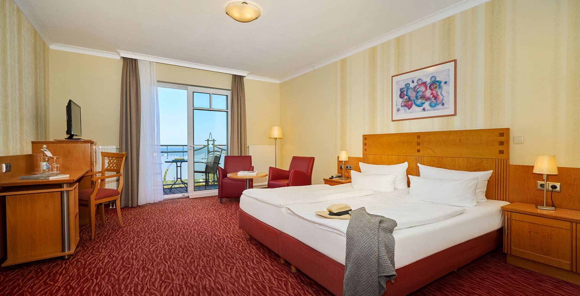 Gemütlichen Zimmer mit Doppelbett, Sessel, Schreibtisch und Meerblick im Strandhotel Prinz von Preussen.