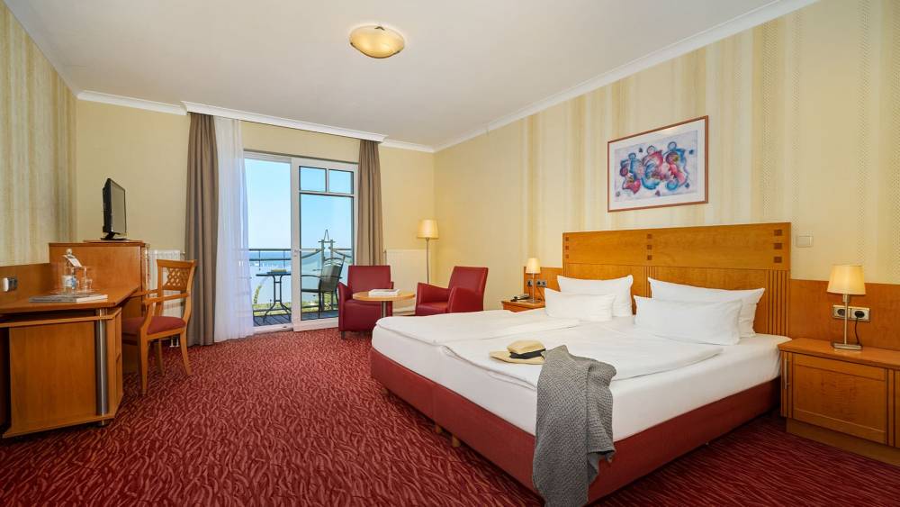 Gemütlichen Zimmer mit Doppelbett, Sessel, Schreibtisch und Meerblick im Strandhotel Prinz von Preussen.