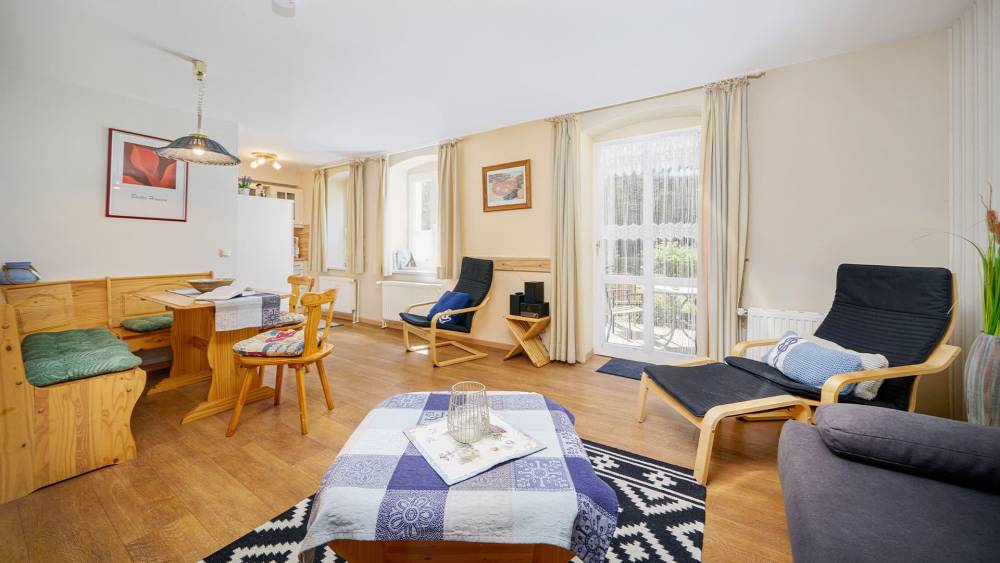 Wohnbereich mit Sitzecke, Esstisch und viel Tageslicht in der Juniorsuite zur Landseite auf Usedom.
