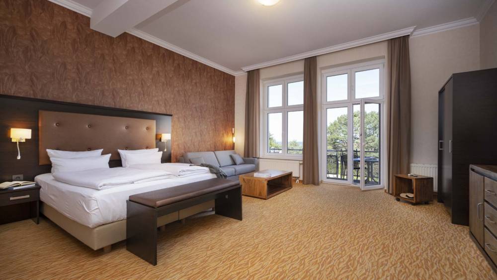 Großes Doppelzimmer im Strandhotel Preußenhof auf Usedom mit Sofa, Balkon und Meerblick.
