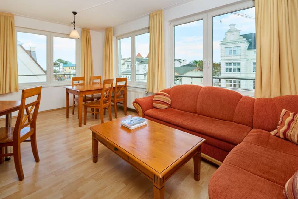 Heller Wohnbereich mit Ecksofa, Couchtisch und Essplatz in den Ferienwohnungen der Schöner Inseln auf Usedom.