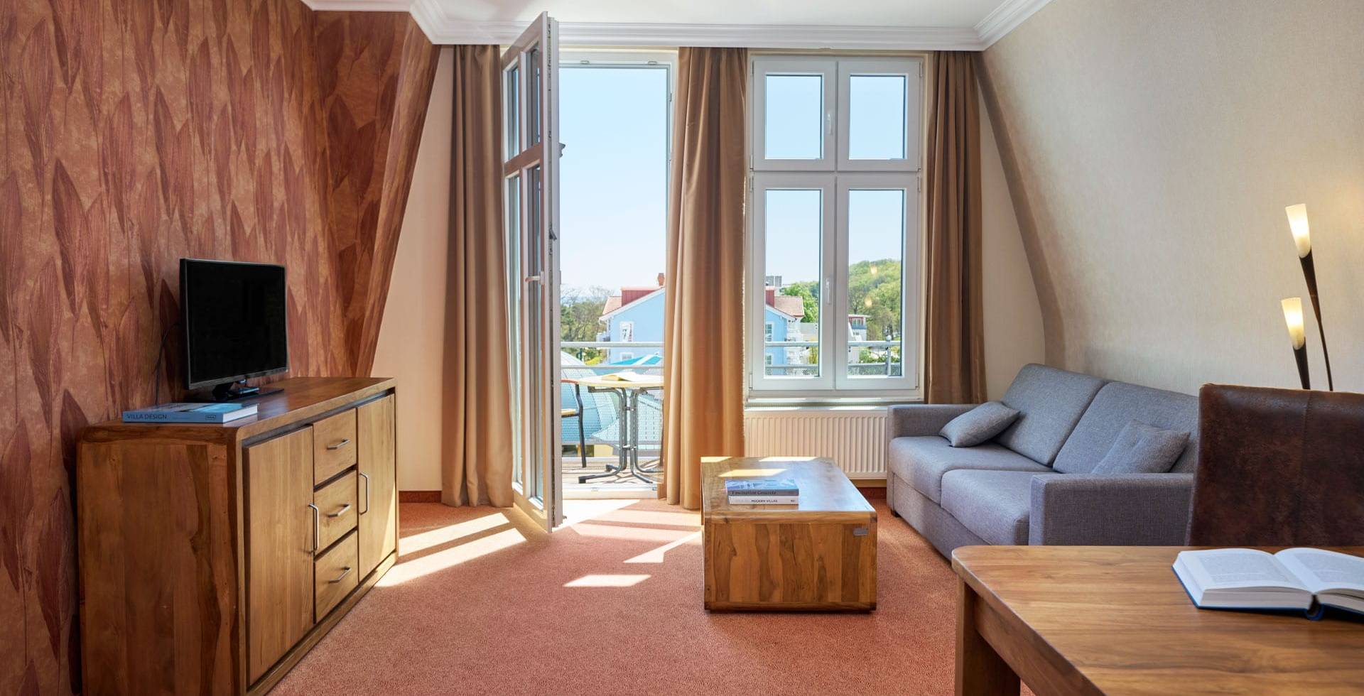 Juniorsuite im Strandhotel Preußenhof mit Sofa, TV, Schreibtisch, Meerblick und Balkon.