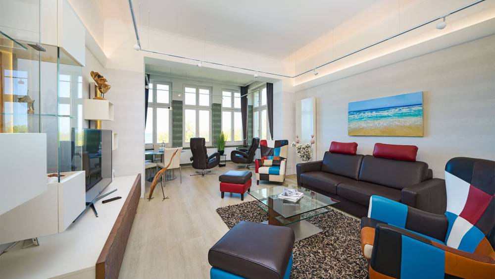 Wohnbereich mit Designermöbeln, Ledersofa und Panoramafenstern in der Ostsee Deluxe Suite auf Usedom.