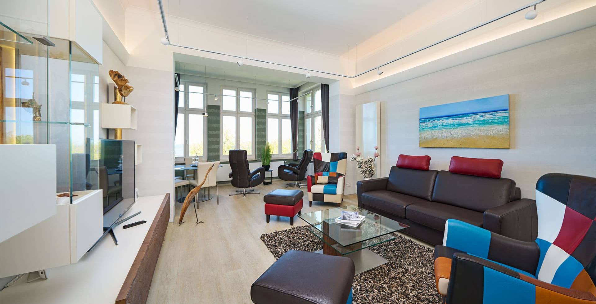 Wohnbereich mit Designermöbeln, Ledersofa und Panoramafenstern in der Ostsee Deluxe Suite auf Usedom.