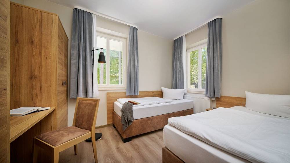 Schlafzimmer mit Doppelbett, Sessel und Fenster in der Familiensuite zur Landseite auf Usedom.