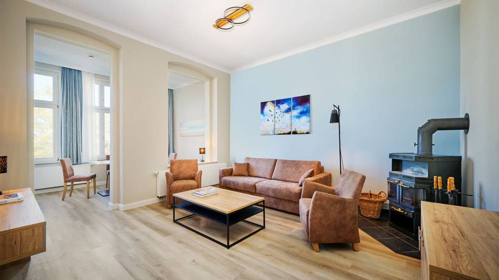 Wohnbereich mit Sofa, Sesseln und hellen Farben in der Familiensuite zur Meerseite auf Usedom.