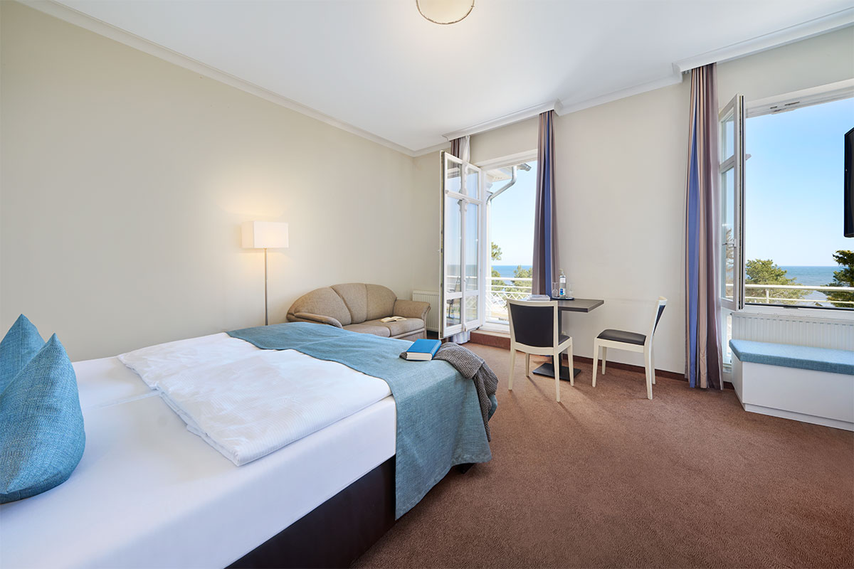 Helles Studio Apartment mit Meerblick, Doppelbett, Sofa und Balkon im Strandpalais in Zinnowitz auf Usedom.