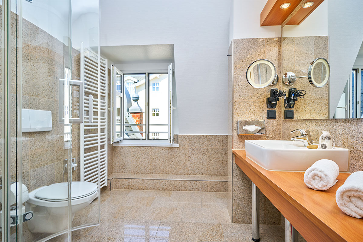 Modernes Bad mit Dusche und Fenster im Strandhotel Garni Kormoran auf Usedom nahe der Ostsee.