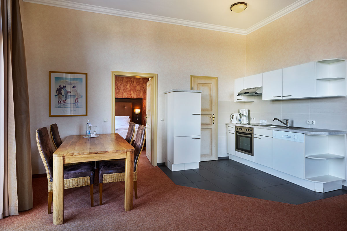 Küche mit Essbereich, Esstisch und vier Stühlen in der Turm Suite des Strandhotel Preußenhof.