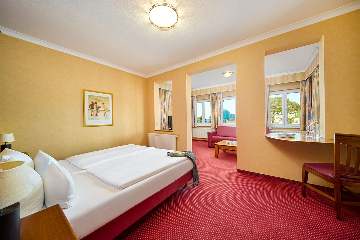 Doppelzimmer Promenade in der Strandvilla Viktoria mit separatem Sitzbereich, Schreibtisch und zwei großen Fenstern.