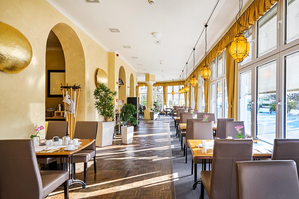 Restaurant Lineti mit Fensterfront zur Promenade und stilvoll eingedeckten Tischen in sonniger Atmosphäre im Urlaub auf Usedom.