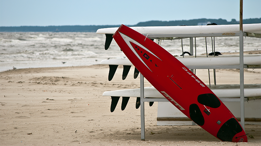 Am Ostseestrand von Usedom liegen mehrere Surfbretter. © Adobe Stock, UsedomCards.de