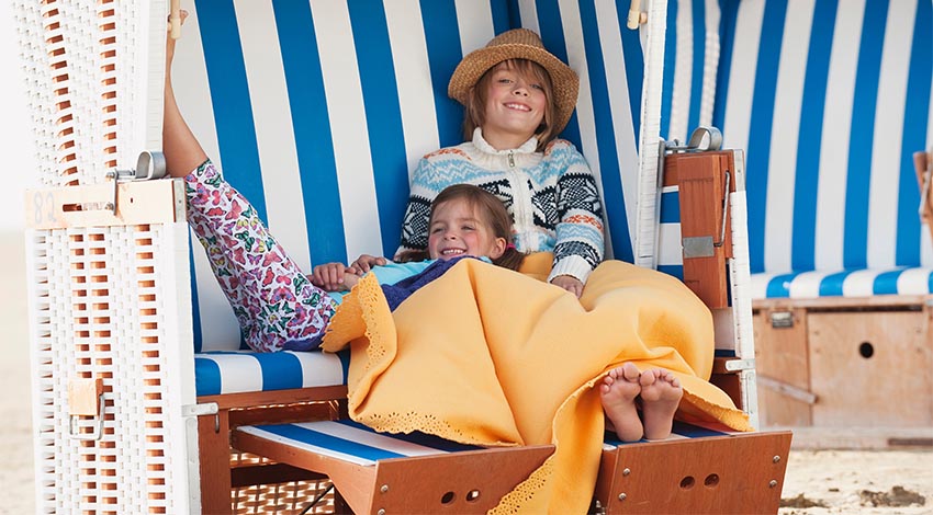 Kinder entspannen sich im Strandkorb an der Ostsee. © Adobe Stock, tunedin